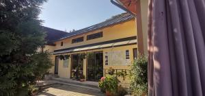 ein gelbes Gebäude mit Pflanzen davor in der Unterkunft Cabana CODRIN in Rausor