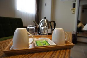 a tray with two mugs and a tea kettle on a table at Hotel Citio Shizuoka in Shizuoka