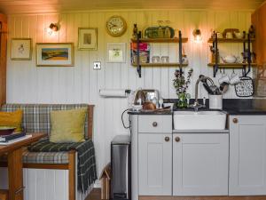 a kitchen with a sink and a couch in a room at Shepherds Hut - Ukc6774 in Llanallgo