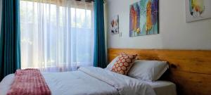 a bed sitting in a bedroom with a window at Barnhouse Cottage - Sauna & Steam bath - in Tigoni in Nairobi