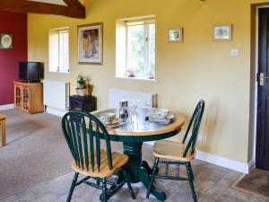 a dining room with a table and two chairs at Barleycorn in Holwell