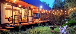 a house with a deck with lights on it at Barnhouse Cottage - Sauna & Steam bath - in Tigoni in Nairobi