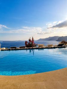 a large swimming pool with a view of the ocean at Grand Canava in Oia