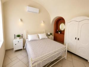 a bedroom with a white bed and a white dresser at Grand Canava in Oia +61 photos
