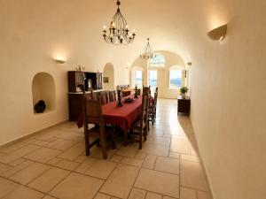 a dining room with a table and chairs and a kitchen at Grand Canava in Oia