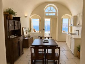 a kitchen with a table and chairs in it at Grand Canava in Oia