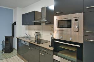 a kitchen with a microwave oven and a sink at Ferienhaushälfte "Ausblick" in Sundhagen-Niederhof
