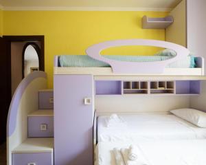 a bedroom with two bunk beds and a yellow wall at Villa Ennio in Ciampino