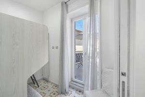 a white room with a mirror and a window at La Casa Di Zio Michelino in Pimonte