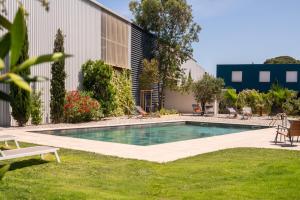 a swimming pool in a yard next to a building at Golden Tulip Hotel & Rooftop Martigues Provence in Martigues