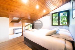 a bedroom with a large bed with a wooden ceiling at Villa Igelak - Hossegor - Centre - Lac - Piscine in Soorts-Hossegor +40 photos