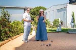 a man and a woman standing next to balls at Golden Tulip Hotel & Rooftop Martigues Provence in Martigues