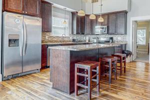 a kitchen with a stainless steel refrigerator and wooden cabinets at Hola Beaches in Corolla