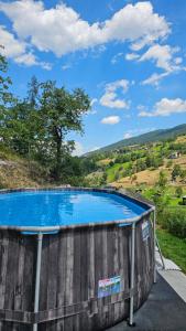 a large blue swimming pool with a hill in the background at Gästehaus auf Camping Grächbiel in Grächen