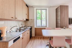 a kitchen with wooden cabinets and a sink and a table at La Pergola by Quokka 360 - Cozy Stay for Mountain Adventures in Leventina in Lavorgo