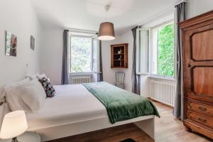 a bedroom with a bed and two windows at La Pergola by Quokka 360 - Cozy Stay for Mountain Adventures in Leventina in Lavorgo +18 photos
