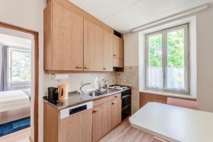 a kitchen with wooden cabinets and a sink at La Pergola by Quokka 360 - Cozy Stay for Mountain Adventures in Leventina in Lavorgo