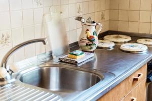 a kitchen counter with a sink and a vase at La Pergola by Quokka 360 - Cozy Stay for Mountain Adventures in Leventina in Lavorgo