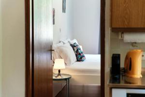 a bedroom with a bed and a table with a lamp at La Pergola by Quokka 360 - Cozy Stay for Mountain Adventures in Leventina in Lavorgo