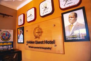 a wall with clocks and a sign for a hotel at Golden Quest Hotel in Entebbe