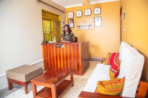 a woman standing at a bar in a room at Golden Quest Hotel in Entebbe