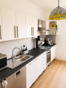 a kitchen with white cabinets and a sink at Troisdorf - City - 64Qm - 1 bis 3 Schlafplätze in Troisdorf