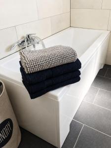 a white bath tub with a pile of towels on it at Troisdorf - City - 64Qm - 1 bis 3 Schlafplätze in Troisdorf +9 photos