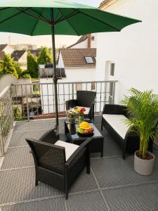 a patio with an umbrella and chairs and a table at Troisdorf - City - 64Qm - 1 bis 3 Schlafplätze in Troisdorf