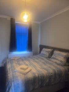 a bedroom with a bed with a blue window at The Blue House in Portsmouth