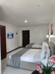 a hotel room with two beds and a flat screen tv at Ricres Hometel R3 in Babak
