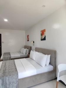 a bedroom with two beds and a chair at Ricres Hometel R3 in Babak