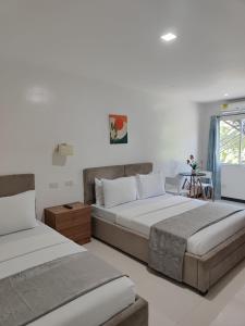 a bedroom with two beds and a window at Ricres Hometel R3 in Babak