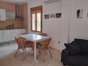 a kitchen and living room with a table and chairs at El balcón de Cuadros in Jaén