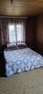 a bedroom with a bed with a blue and white comforter at Macanovic Country House in Glibaći +3 photos