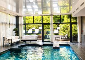an indoor pool in a living room with windows at Hotel & Spa Le Grand Monarque, BW Premier Collection in Chartres