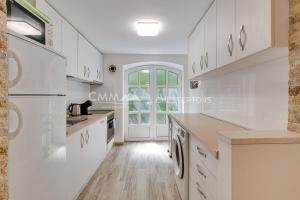 a kitchen with white cabinets and white appliances at Villa Masha in Rijeka Reževići