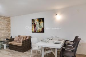 a white dining room with a white table and chairs at Villa Masha in Rijeka Reževići