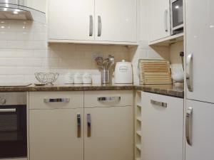 a kitchen with white cabinets and white appliances at 18 Elm Court in Keswick