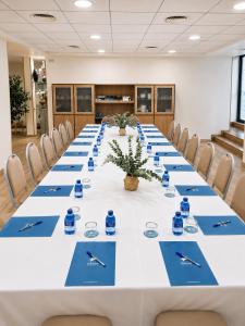 a conference room with a long table with blue chairs at Hotel Real in Lleida