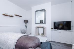 a bedroom with a bed and a tv on a wall at Stylish 2-Bed House Sleeps 4 in Saint Helens