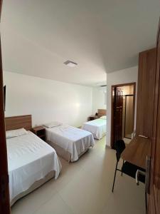 a hotel room with two beds and a desk at Hotel Pacaraima in Mecalineta +13 photos