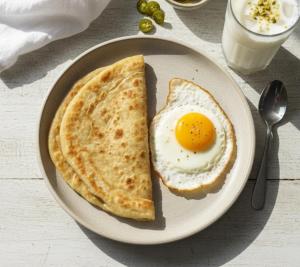 a plate with an egg and two pieces of toast at Hotel Regent DHA in Karachi