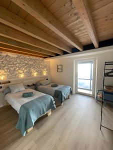 a bedroom with two beds and a large window at Verde & Mar in Castro-Urdiales