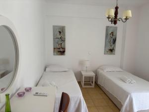 a room with two beds and a table with a mirror at Alexandra Villa in Bali