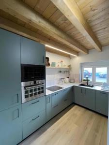a kitchen with white cabinets and a wooden ceiling at Verde & Mar in Castro-Urdiales