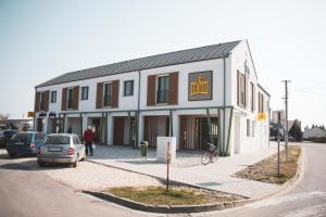 a building on a street with cars parked in front of it at Lebeco Apartman in Kolárovo