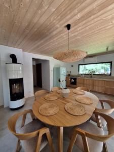 a dining room with a wooden table and chairs at Fale i Igły in Sasino