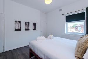 a white bedroom with a large white bed and a window at Stylish 2-Bed House Sleeps 4 in Saint Helens
