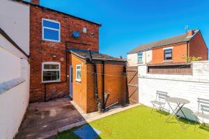 a small backyard with a brick building and a fence at Stylish 2-Bed House Sleeps 4 in Saint Helens