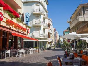 a street with tables and chairs in front of a building at De Amicis Sea Home in Gabicce Mare